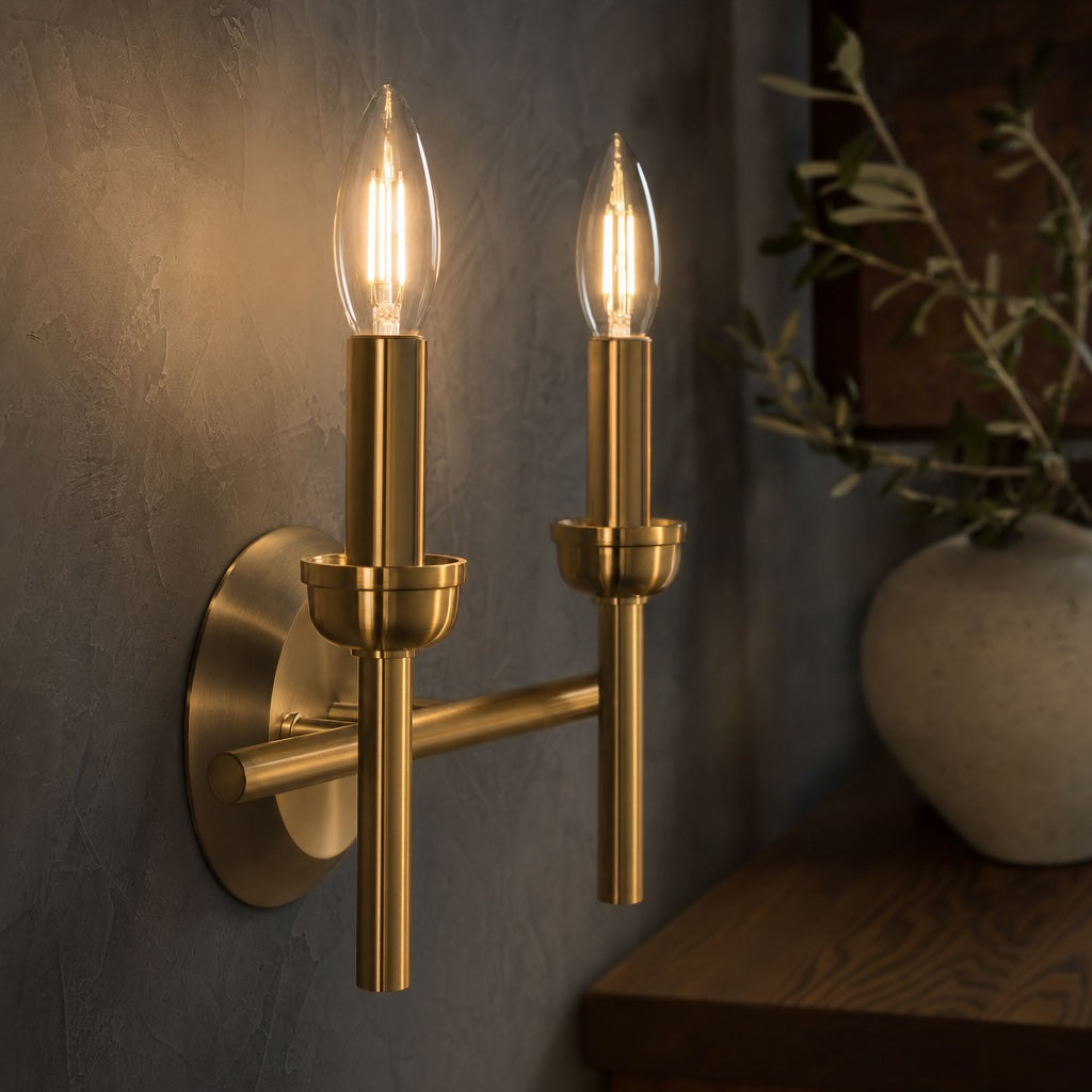 Dulora C35 Clear Candle LED Bulb in 2700K Warm White installed in a modern brushed brass wall sconce
