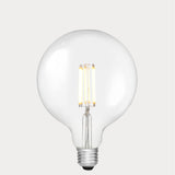 Dulora 11W E27 LED globe bulb in clear glass, glowing with 3000K soft white light.
