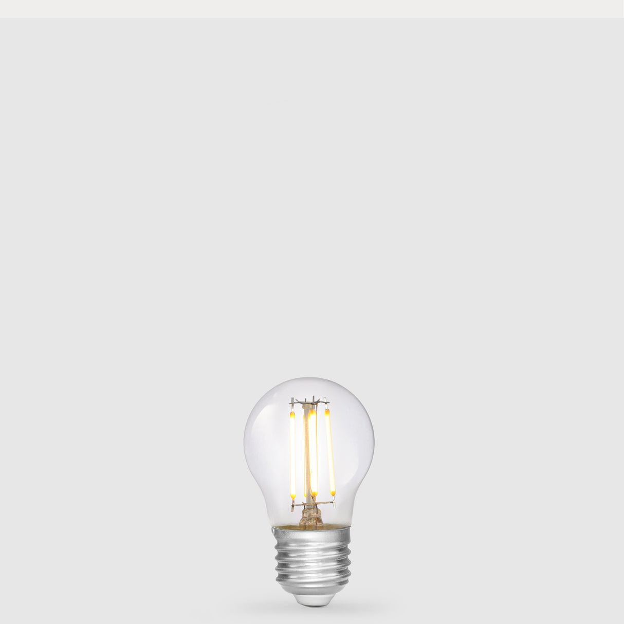 Dulora 4W 12-24 Volt AC/DC Fancy Round LED Bulb E27 in Warm White illuminated with warm light through clear round glass