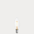 Dulora 4W B15 LED candle bulb in clear glass, glowing with 2200K extra warm white light.