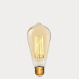 Dulora 4W Edison Vintage LED Bulb E27 in Ultra Warm White glowing deep amber through vintage ST64 glass