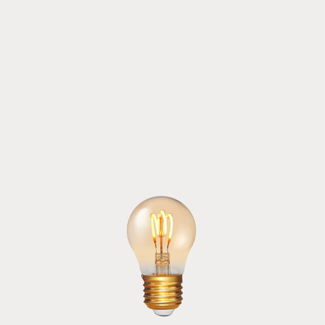 Dulora 4W Vintage Fancy Round LED Bulb E27 in Ultra Warm White glowing with deep amber warmth through tinted glass