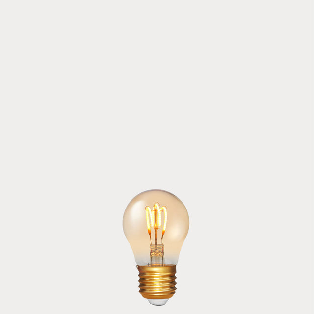 Dulora 4W Vintage Fancy Round LED Bulb E27 in Ultra Warm White glowing with deep amber warmth through tinted glass