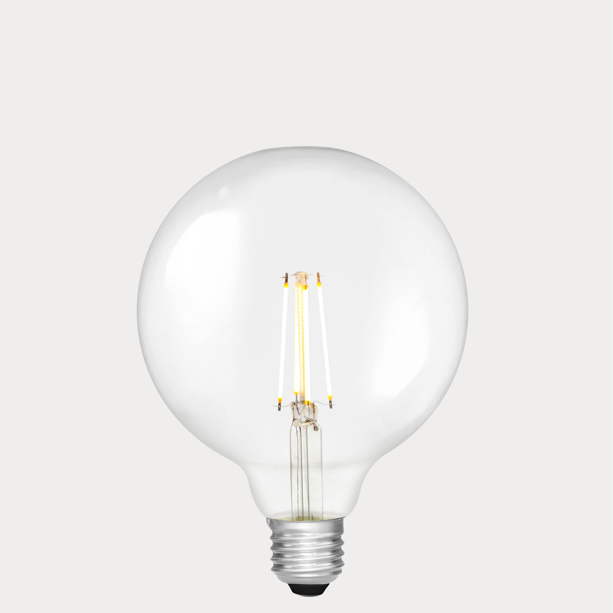 Dulora 7W E27 LED globe bulb in clear glass, glowing with 2700K warm white light.