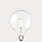 Dulora 7W E27 LED globe bulb in clear glass, glowing with 2700K warm white light.