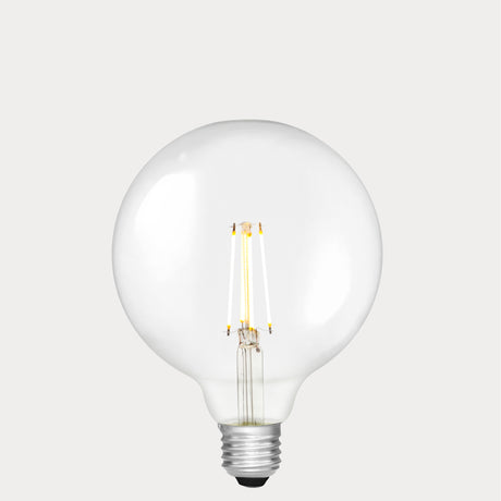 Dulora 7W E27 LED globe bulb in clear glass, glowing with 2700K warm white light.
