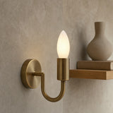 Luxury Wall Mounted Dulora Frosted Dimmable Candle LED Bulb in 2700K Warm White illuminated inside a modern brushed brass U-shaped wall sconce.